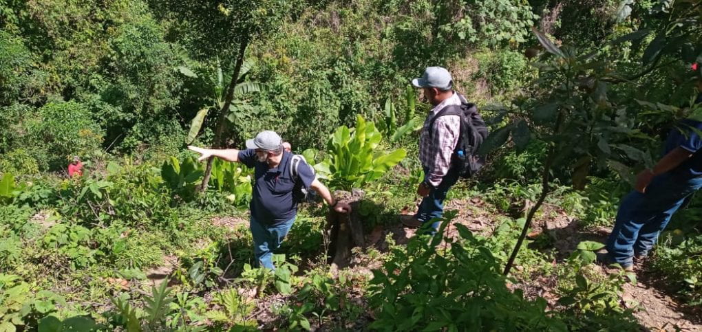 Tony Sauder and EWB’s Arturo Ujpan discussing the steep slopes down to the spring catchment at Panyebar